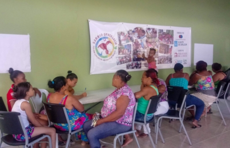 Grupo de mulleres sentadas en mesas nunha formación no barrio Santa Lucía, na República Dominicana